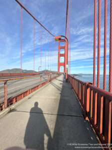 a bridge with a red railing and a shadow
