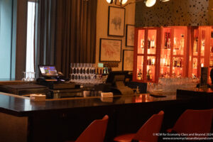 a bar with a cash register and wine glasses