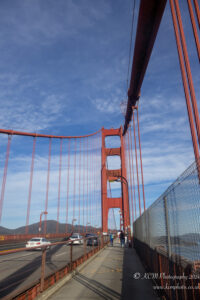 a red bridge with cars and people walking on it