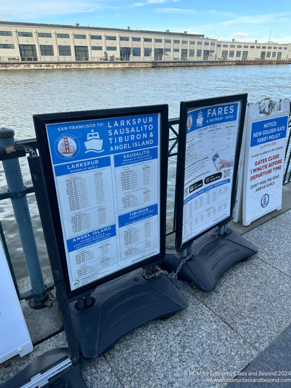 a group of signs next to a body of water