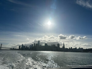 a city skyline with water and clouds in the sky