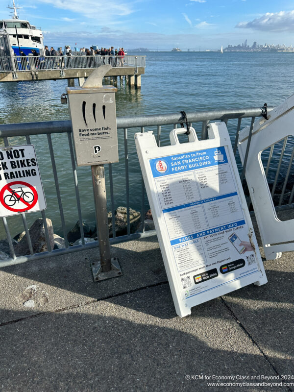 a sign on a railing next to a body of water