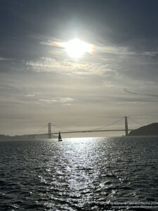 a sailboat in the water with a bridge in the background