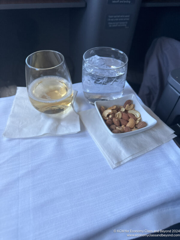 a plate of nuts and a glass of water on a table