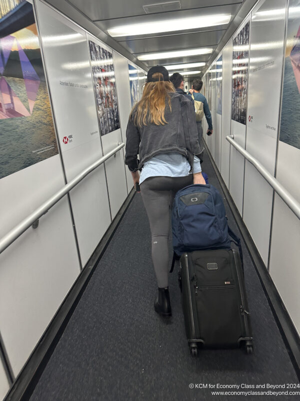 a woman pulling luggage down a hallway