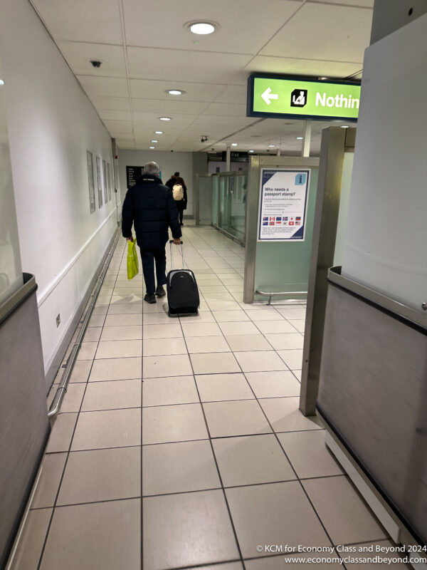 a person pulling a suitcase in a hallway