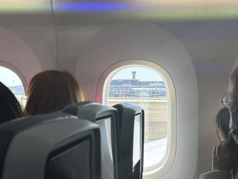 a woman sitting in an airplane looking out the window