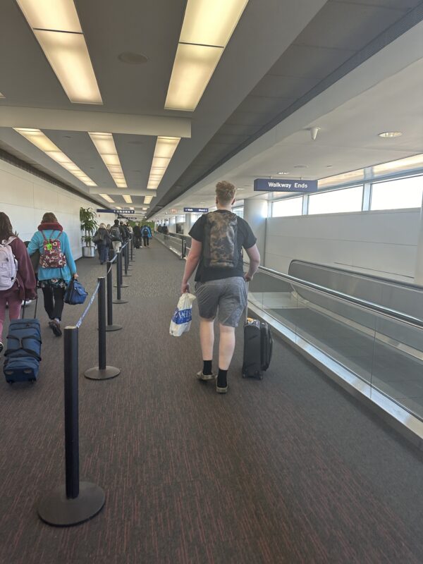 a man walking with luggage in an airport