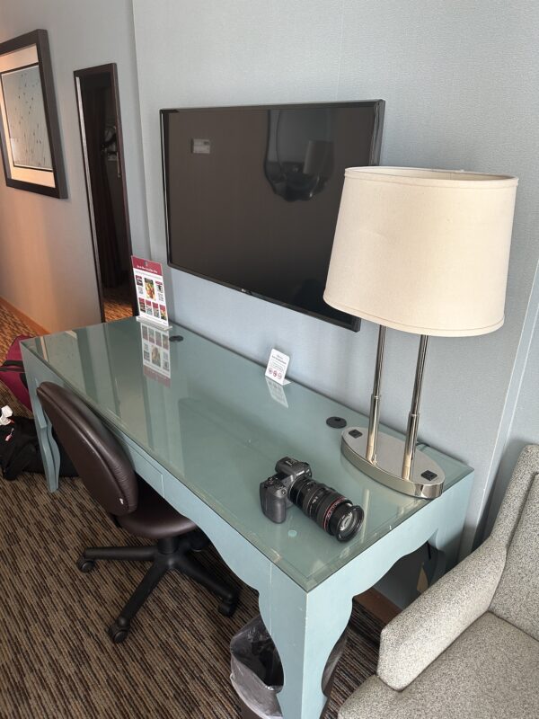 a desk with a lamp and a mirror on the wall