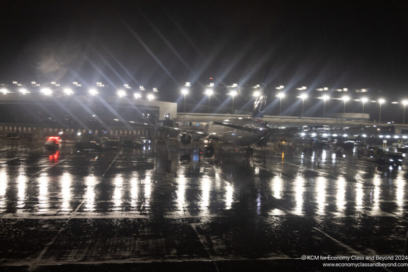 an airplane on a wet runway at night