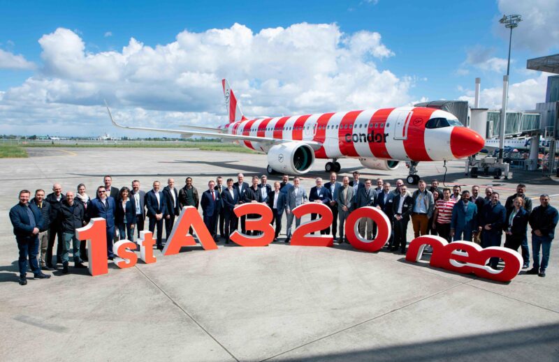 a group of people standing in front of a large red and white airplane