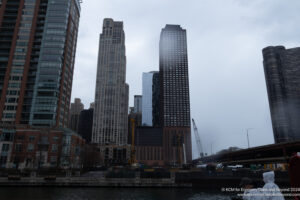 a city skyline with tall buildings and a body of water