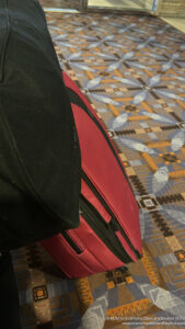 a red suitcase on a patterned carpet