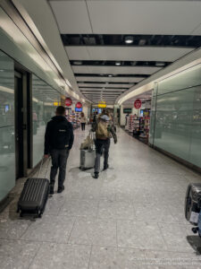 people walking in a hallway with luggage