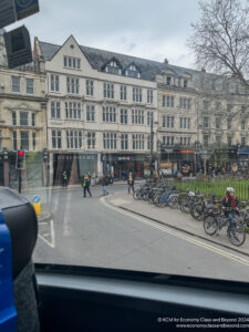 a group of people walking on a street with bicycles parked on the side