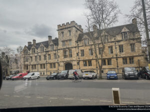 a person riding a bicycle in front of a large brick building