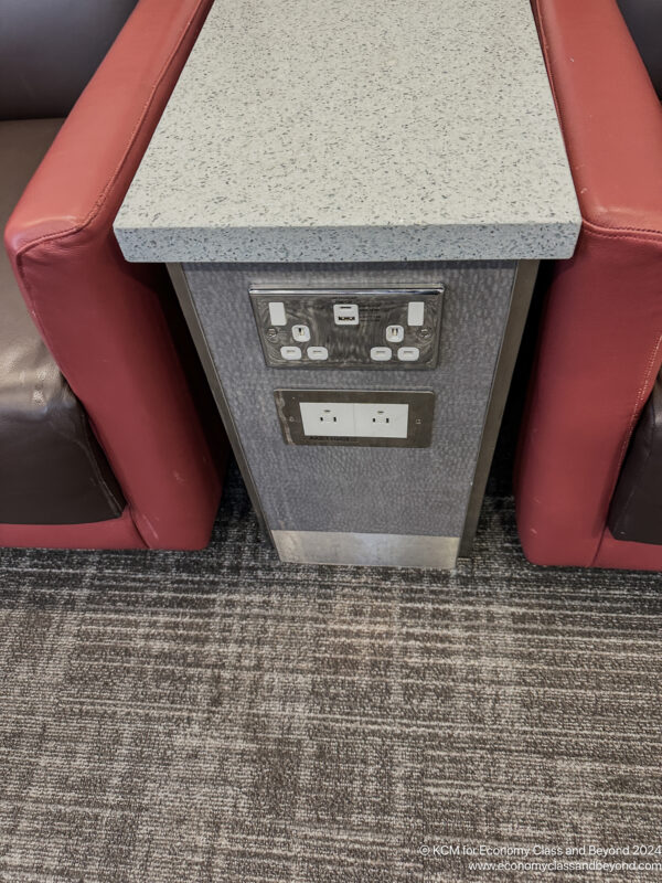 a table with power outlets and red chairs