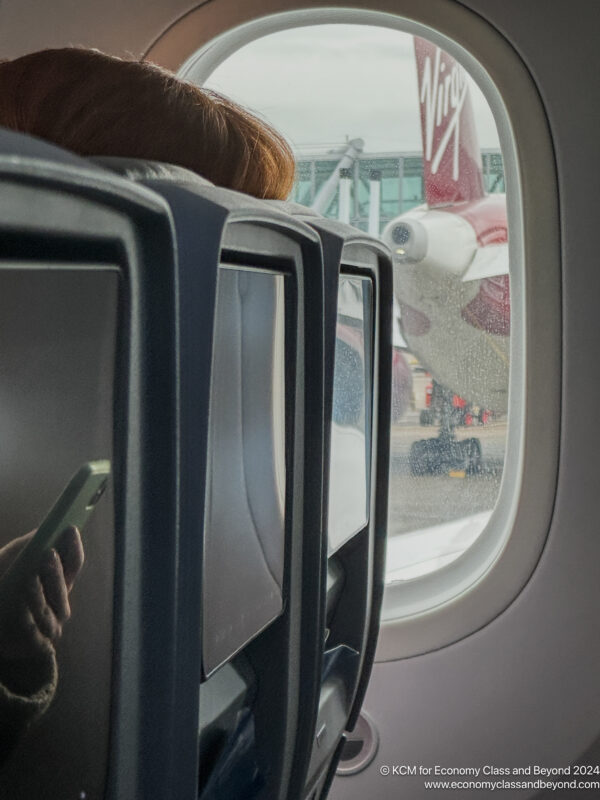 a person sitting in an airplane seat looking out the window