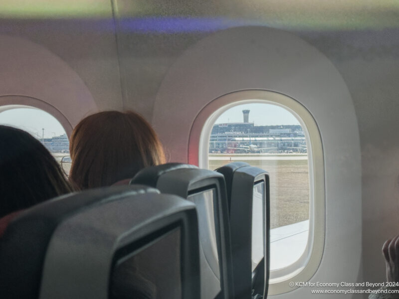 a group of people looking out a window on an airplane