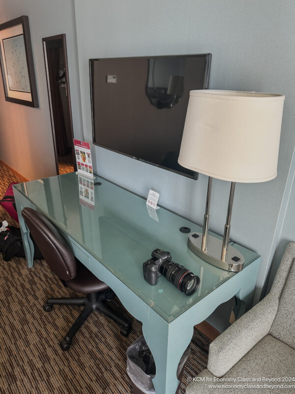 a desk with a lamp and a mirror on it