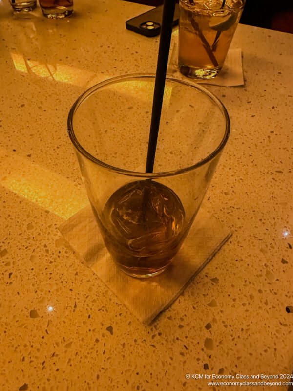 a glass with a straw and ice cubes on a table