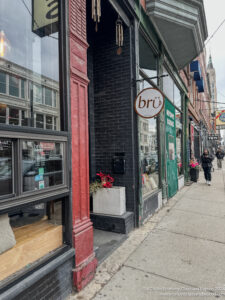 a sidewalk with storefronts and people walking on it