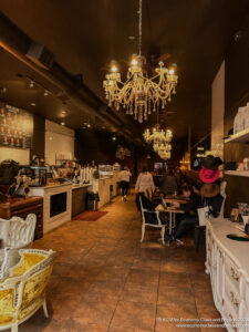 a room with a chandelier and people sitting at tables