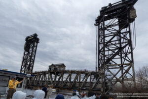 a group of people standing near a bridge