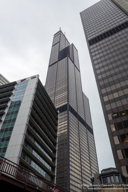 a tall buildings with a sky scraper with Willis Tower in the background