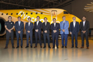 a group of men standing in front of a yellow airplane