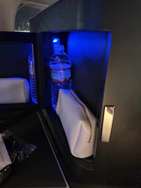 a small black locker with a bottle of water and a white bag
