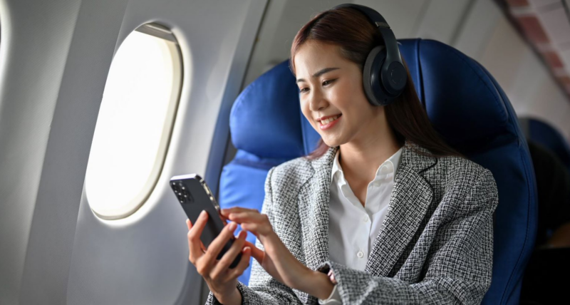 a woman wearing headphones and looking at a phone