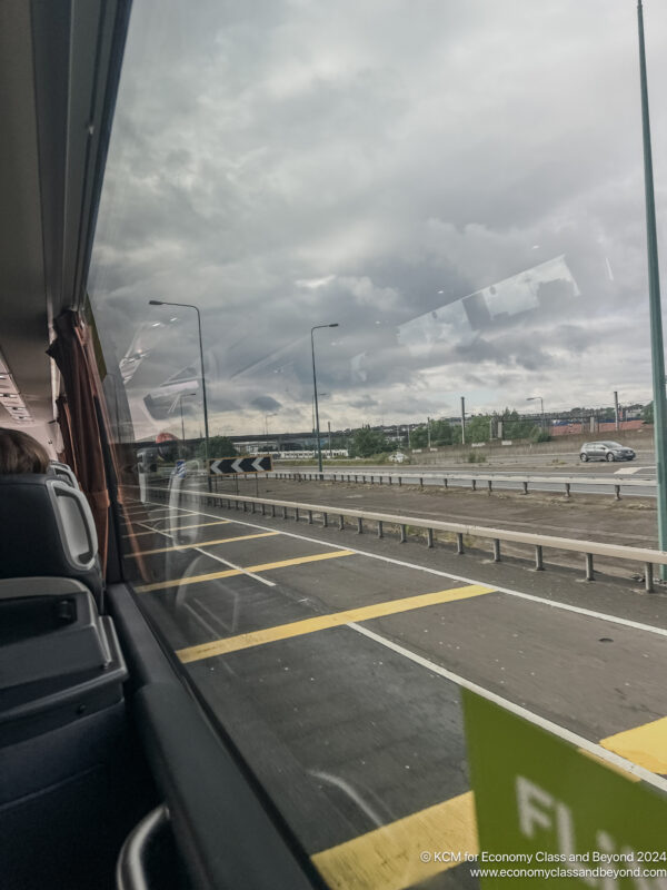 a view from a bus window of a road and a city