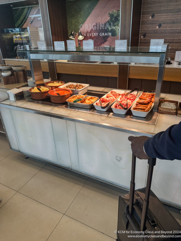 a person with luggage looking at food on a counter