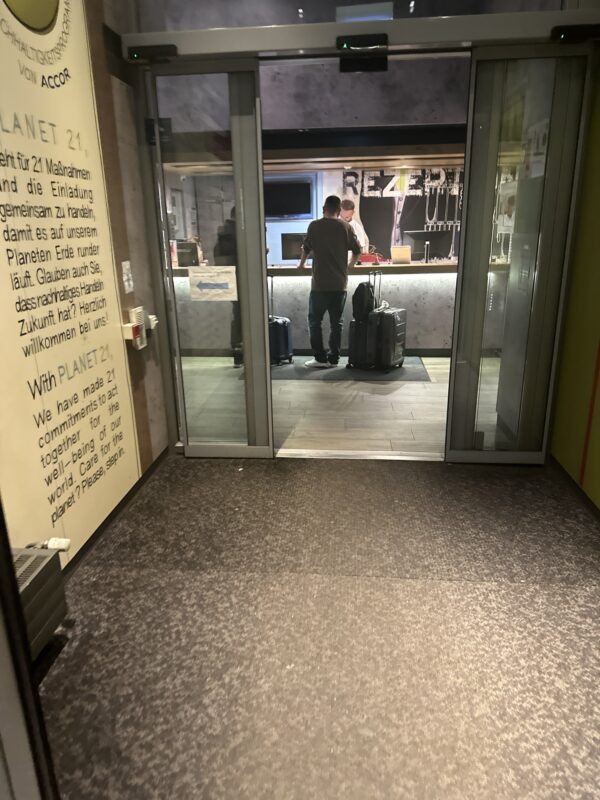 a couple of men standing in front of a glass door