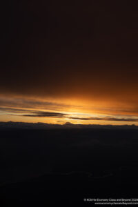 a sunset over clouds and a body of water