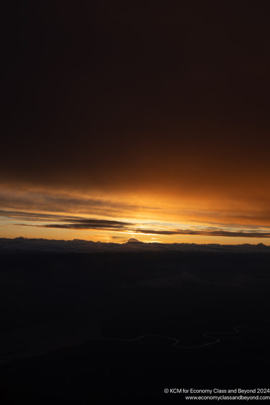 a sunset over clouds and a body of water