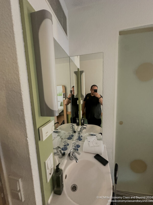 a man taking a selfie in a bathroom mirror