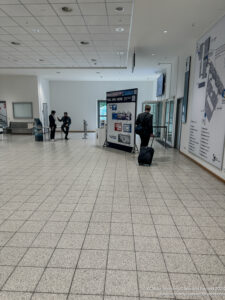 people in a building with a large white board and a man with luggage