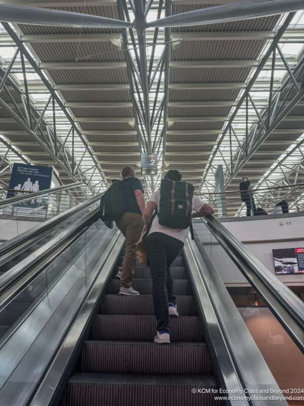 two people walking up an escalator