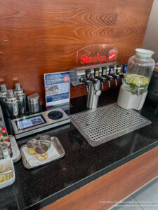 a counter with a drink dispenser and a drink dispenser