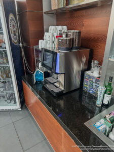 a coffee machine with coffee beans and coffee cups on top