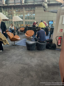 people sitting in a room with chairs and tables