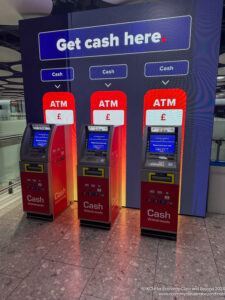 a group of cash machines in front of a large sign