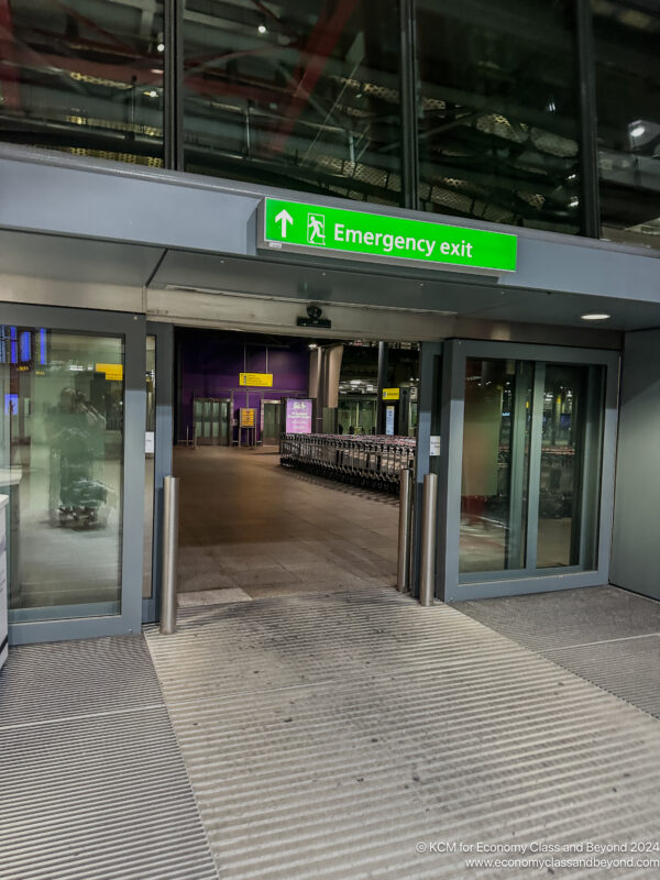 a large glass entrance with a green sign