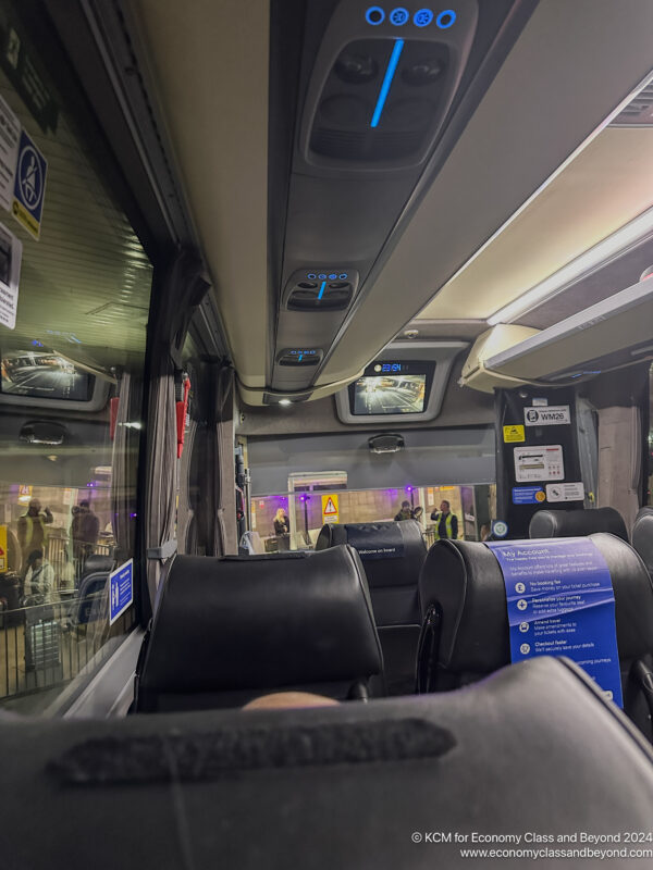 inside a bus with seats and a person's leg