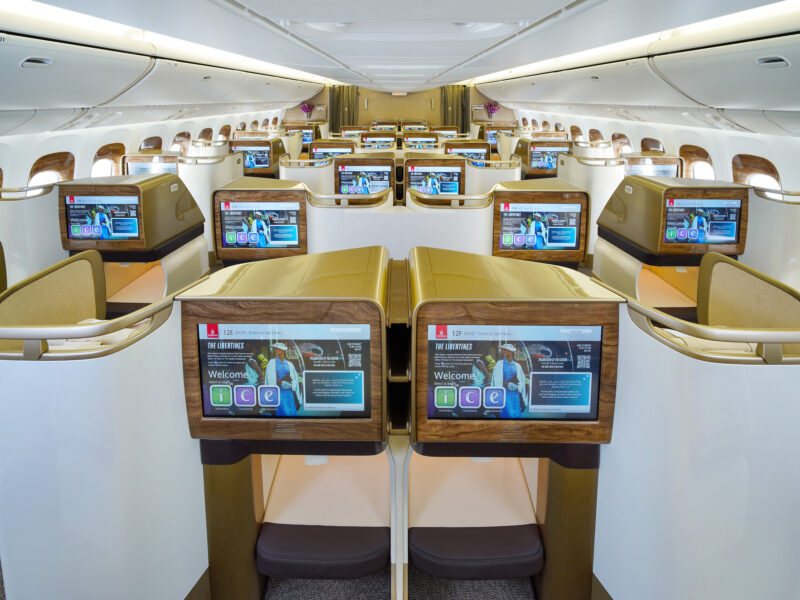 a row of seats with monitors on the side