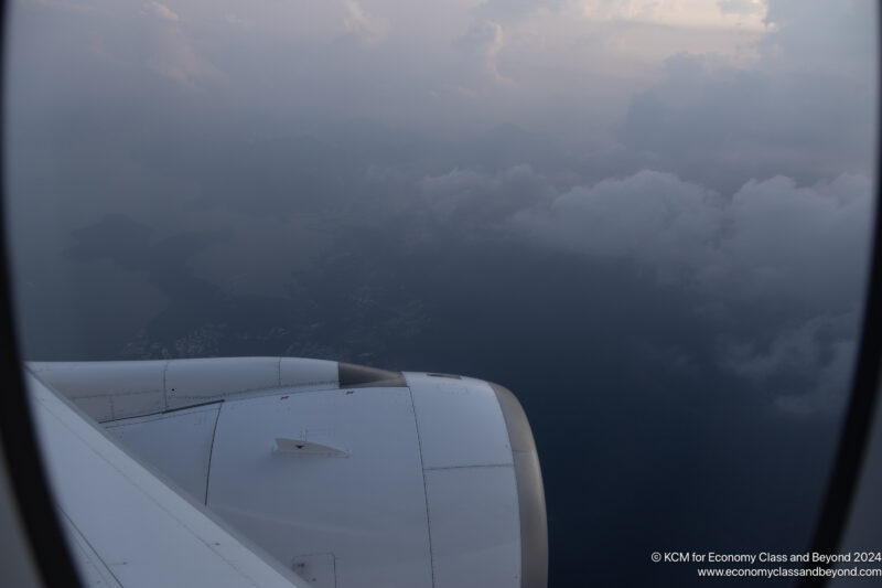 an airplane wing with clouds in the background