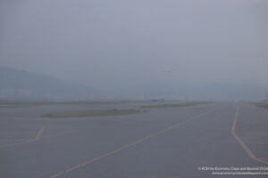 an airplane flying over a runway