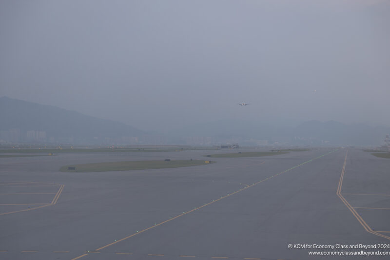 an airplane flying over a runway